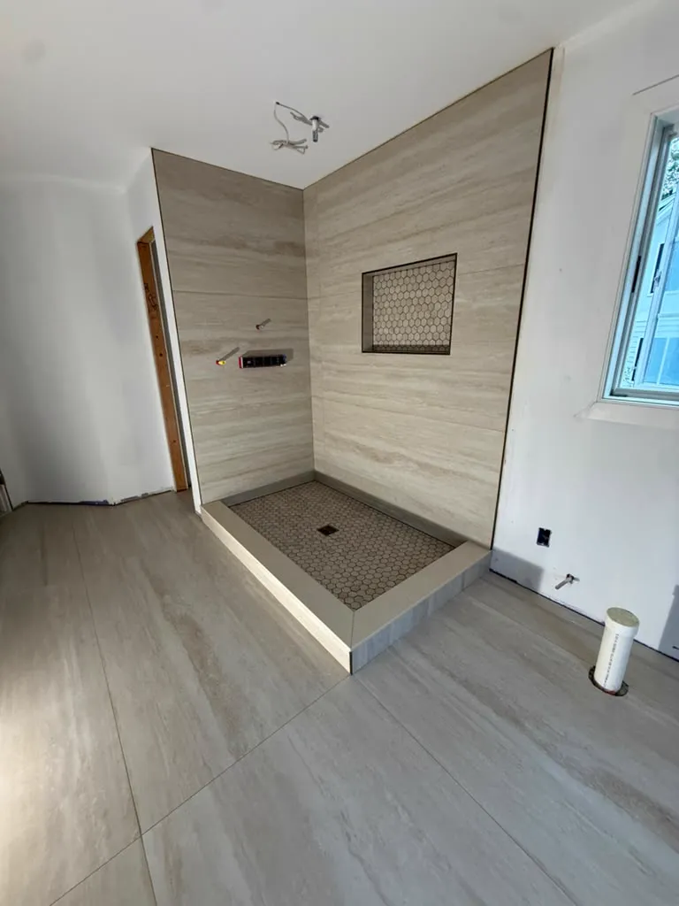 Travertine walk-in shower with niche and window