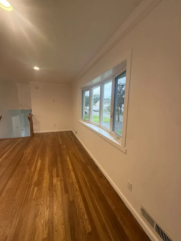 Room with refinished hardwood floors and fresh trim