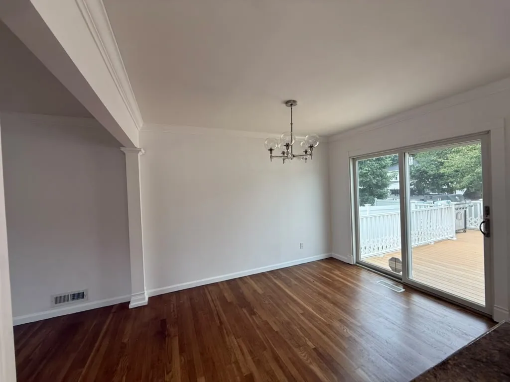 Living room with slider door and refinished hardwood floors
