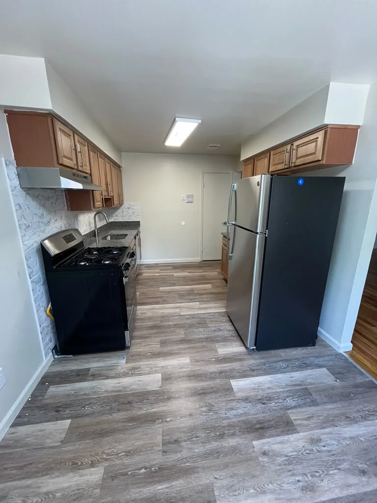 Galley kitchen with wood cabinets and black appliances